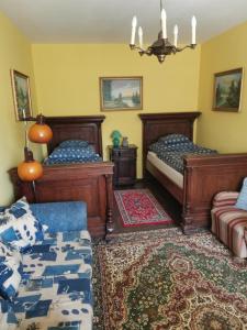 MátraterenyeMátrai Vadászház 2的一间带两张床和一张沙发的卧室