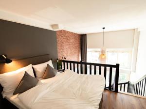 汉堡PHNX Aparthotel Hamburg的一间卧室配有带白色床单和枕头的床。