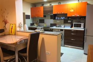 康斯坦察Casa Roxana的厨房配有橙色橱柜和桌椅