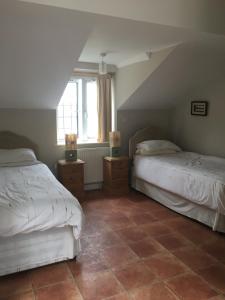HooeRosemary Cottage的阁楼卧室配有两张床,铺有瓷砖地板。