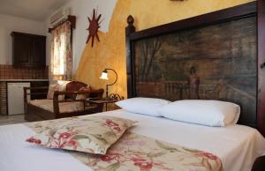 圣安娜纳克索斯维拉达纳伊酒店的一间卧室配有一张带大型木制床头板的床