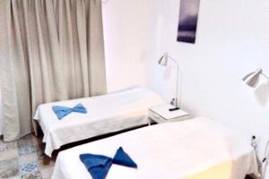 巴耶格兰雷伊Efigenia playa/mar 2的客房内的两张床和蓝色枕头