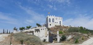 TardientaHotel Cueva Tardienta Monegros-Adults Only的山顶上一座有旗帜的建筑