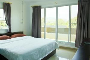 北碧由迪伊客房和咖啡酒店的一间卧室设有一张床和一个大窗户