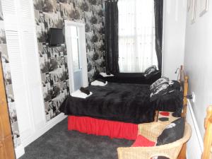 布莱克浦百利酒店 的一间卧室设有一张黑色的床和一个窗户。