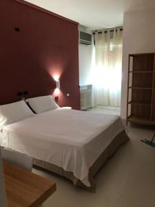巴里里维埃拉酒店的卧室设有一张白色大床和一扇窗户。