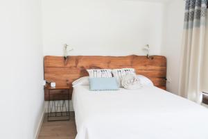 El Pinar del HierroCasa Viges的卧室配有白色的床和木制床头板