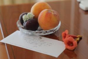斯楚雅Vila Tartini的坐在桌子上的一碗水果,配上纸条