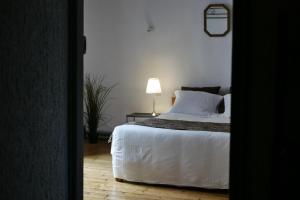 圣戈尔捷Les Oiseaux de Passage的一间卧室配有一张床和一张桌子上的台灯