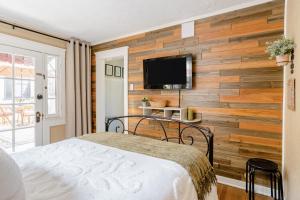长滩Casita Charm, Cozy Character的一间卧室设有木墙、一张床和一台电视。
