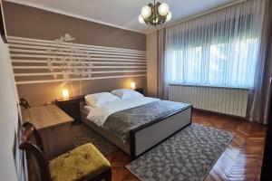 别洛瓦尔Apartman Škudar的卧室配有1张床、1张桌子和1把椅子