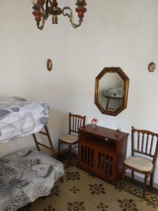 马蒂诺La casa di Alex的一间卧室配有一张床、镜子和两把椅子