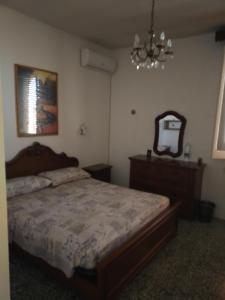 马蒂诺La casa di Alex的一间卧室配有一张床、镜子和吊灯