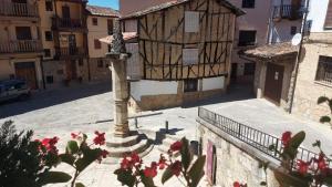 Valverde de la VeraCasa Rural La Picota的一条有建筑和红花柱的街道