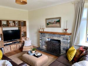 罗厄德南Blair Cottage的客厅设有壁炉和电视。