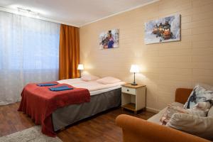 罗瓦涅米罗瓦涅米城市公寓的配有一张床和一把椅子的酒店客房
