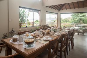 布希奥斯GUAPAS BUZIOS Exceptional House - Ferradurinha的窗户间里的一张长桌子和食物