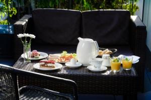 克尔斯特尔巴赫Hotel Athen Kelsterbach Frankfurt Airport的餐桌,柳条椅上备有茶具