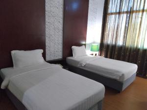 斯里巴加湾市昆普勒克吉拿27号酒店的酒店客房设有两张床和窗户。
