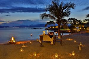 宁凡湾L'Alya Ninh Van Bay的海滩上的一张桌子,上面有蜡烛和灯光