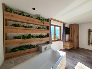 海利根布卢特HIESERHOF - Superior Alpine Apartments的墙上设有植物浴缸的浴室