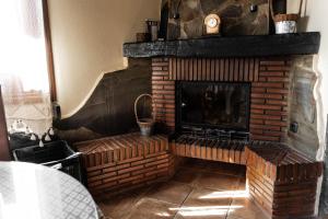 兰哈龙Lanjarón Rural Apartamentos的客厅设有砖砌壁炉及电视