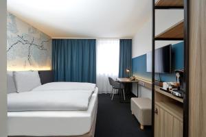 莱比锡莱比锡H4酒店的配有一张床和一张书桌的酒店客房