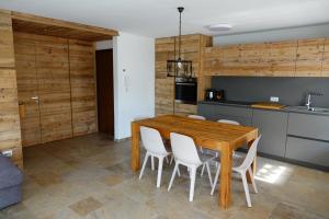 卡里索洛Appartamento 29的厨房配有木桌和白色椅子