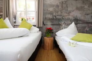 萨尔茨堡Apartments Ante Portas的配有白色床单和绿色枕头的客房内的两张床