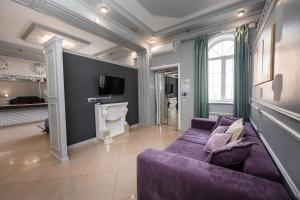 马哈奇卡拉Krepost Mini Hotel的客厅配有紫色沙发和壁炉