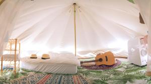 桃园市晃晃印地安帐棚露营区的一间卧室配有一张床,帐篷内备有吉他