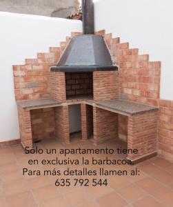 阿尔巴拉辛Apartamentos Río Guadalaviar的一个带炉灶的室外砖比萨饼烤箱