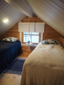 KyläniemiVilla Taikuri的阁楼卧室设有两张床和窗户。
