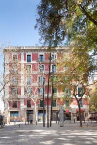 巴塞罗那Casa Vaganto的前方树木林立的街道上的建筑