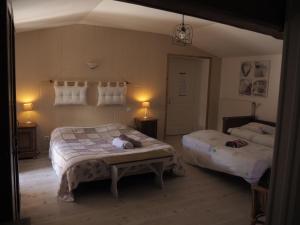 Saint-Germain-la-Ville佩里耶酒店的一间卧室配有两张床和一张桌子