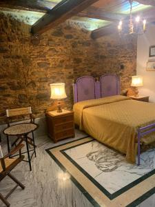 SantʼOnofrioB&B Le Casette的一间卧室设有一张床和砖墙