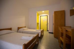 贝雅HI Beja - Pousada de Juventude的酒店客房带两张床和黄色门
