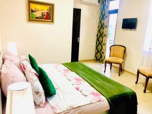 姆兹瓦内康茨基Holiday House Green Cape Batumi的一间卧室配有一张带绿色棉被的床
