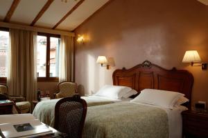 威尼斯比三兹奥酒店的酒店客房带两张床和一张桌子以及椅子。