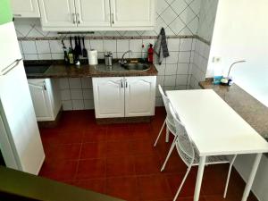 圣地亚哥海滩casa mariposa的厨房配有白色桌子和水槽