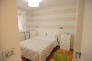 维戈Apartamento Vigo Centro con Garaje的一间小卧室,配有白色的床和绿色地毯