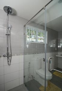 塔卡马卡冲浪者海滩自助式小屋酒店的一间带卫生间和玻璃淋浴间的浴室