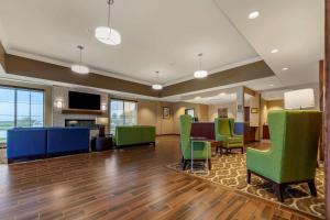 格兰德岛Comfort Suites的一个带绿色椅子和桌子的办公大厅