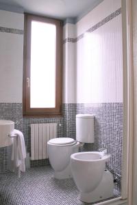 托尔托纳HOTEL OASI的一间带卫生间、水槽和窗户的浴室