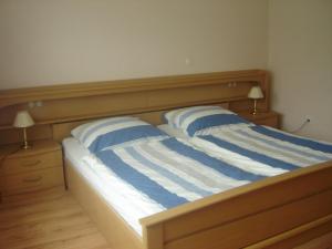 米德尔哈根Ferienwohnung Kathrin Kankel Alt Reddevitz的一张带两个蓝色和白色条纹枕头的床
