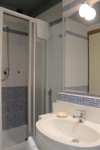 托尔托纳HOTEL OASI的浴室配有盥洗盆和带镜子的淋浴