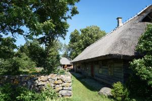Tammese安妮休闲农场农家乐的一座带茅草屋顶和石墙的古老房屋
