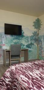 奥瓦尔科德瓦尔德奥拉斯Hotel O Camiño的卧室配有壁画、床和书桌