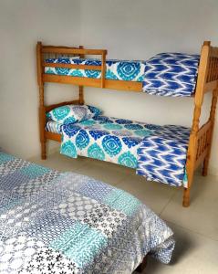 帕拉蒂Recanto da Nice的一间卧室配有两张双层床,铺有蓝色和白色的床单