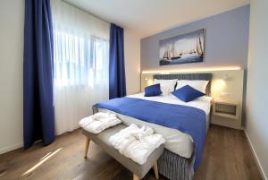 马林斯卡Villa Lungomare的卧室配有蓝色和白色的床,并在长凳上配有毛巾